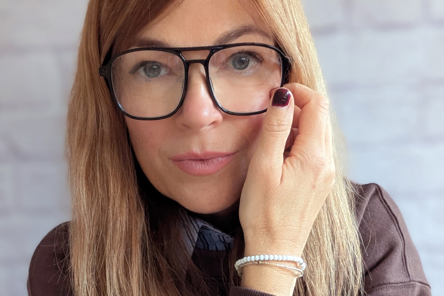 Frau mit moderner Doppelsteg-Lesebrille im 80er Jahre Stil