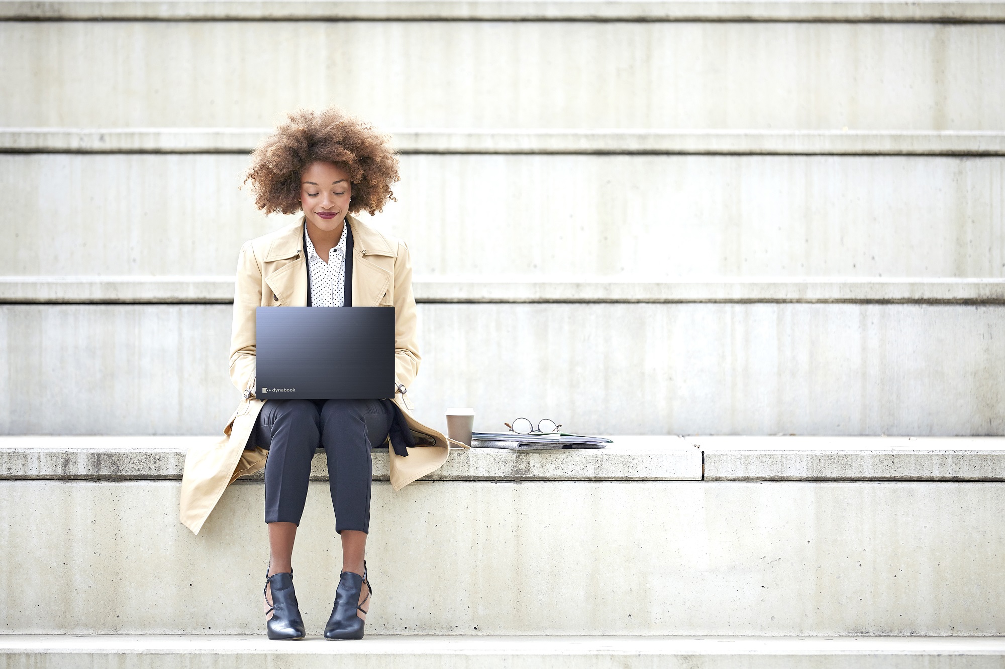 Junge Geschäftsfrau mit Laptop auf einer Treppe